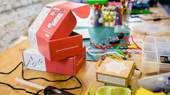 TüftelBoxen und Mikrocontroller stehen in Benutzung auf einem Tisch.