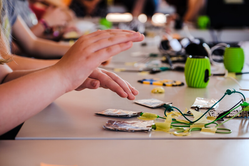 E! Kinderh&auml;nde arbeiten mit einem MakeyMakey Mikrocontroller.
