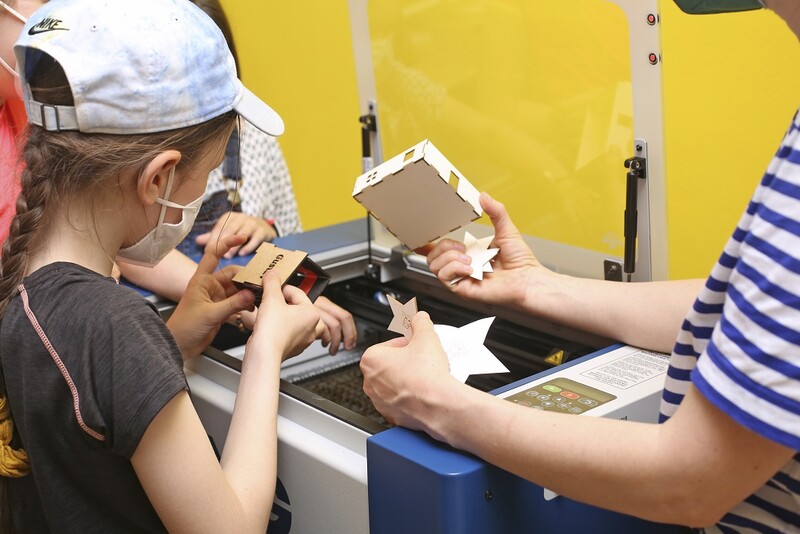 E! Ein M&auml;dchen t&uuml;ftelt mit einem Lasercutter.