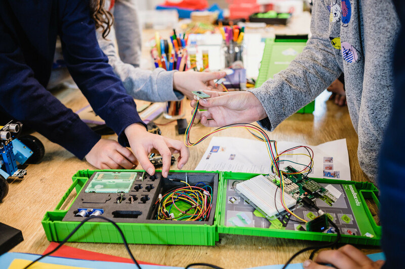 Mehrere Jungedliche T&uuml;fteln mit einer senseBox.
