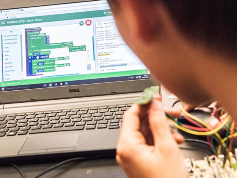 Ein Workshop Teilnehmer t&uuml;ftelt an der Verkabelung f&uuml;r sein Projekt.