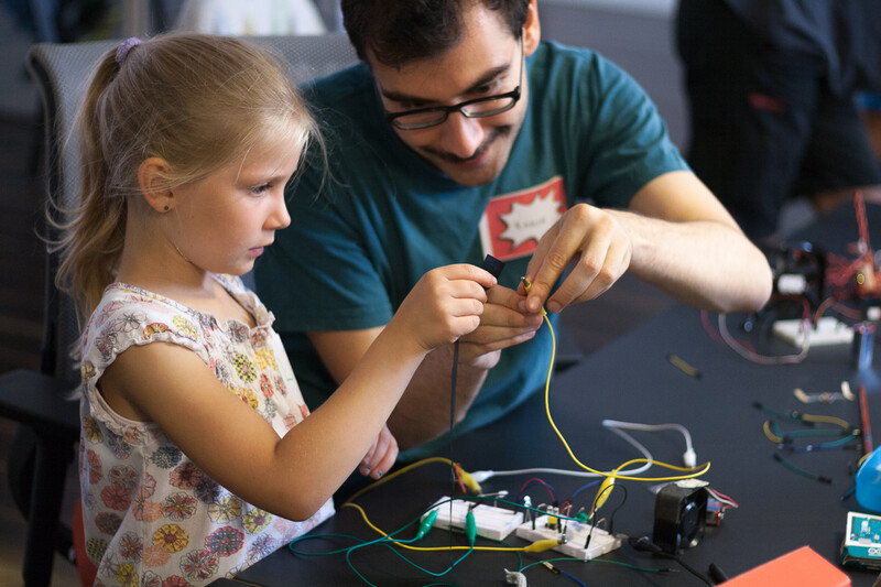 Ein M&auml;dchen im Grundschulalter und Tutor im Workshop programmieren gemeinsam einen Roboter mit Makey Makey.